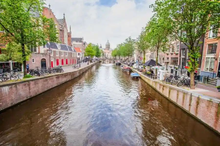 Discover Kromboomssloot, the charming crooked canal in Amsterdam Kromboomssloot crooked canal with historic warehouses in Amsterdam