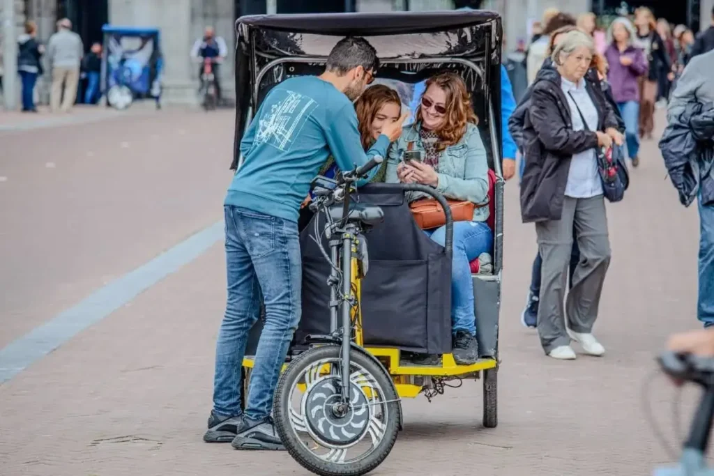 bike taxi driver assisting passengers before ride in Amsterdam city